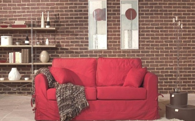 canapé rouge salon mur papier peint brique étagères en bois 