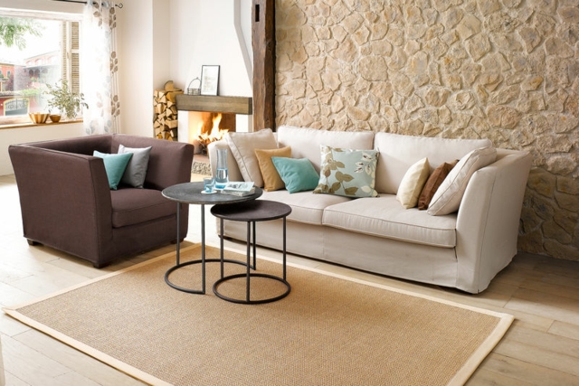 tapis design en fibres naturelles beige canapé table de salon design coussins mur en pierre