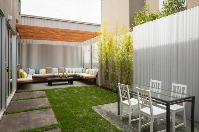 clôture de jardin en pvc blanche canapé de jardin coussins table basse noire chaise de jardin en bois blanche