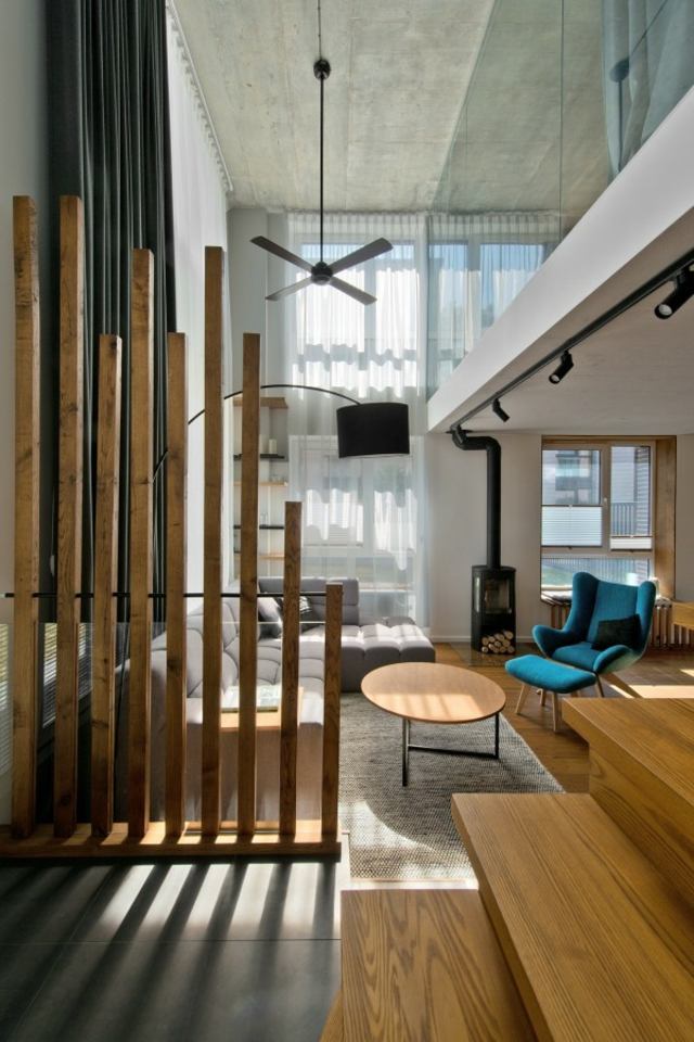 salon aménagement design canapé d'angle gris fauteuil bleu pouf luminaire suspension séparateur bois table basse
