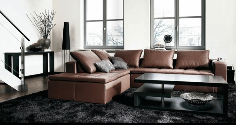 intérieur salon design tapis de sol noir canapé d'angle beige déco coussins table basse 