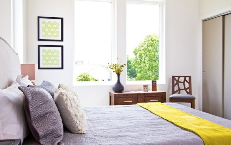 chambre à coucher idée aménagement design lit moderne coussins cadres tableau déco chaise meuble bois