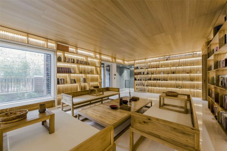 maison familiale design table bois sur mur canapé cousssins bibliothèques 