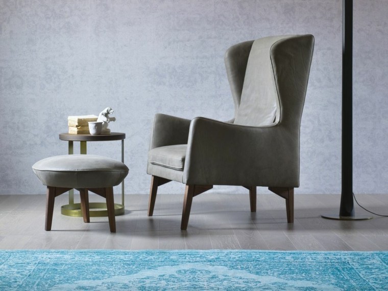 fauteuil bergère en cuir gris pouf tapis de sol bleu