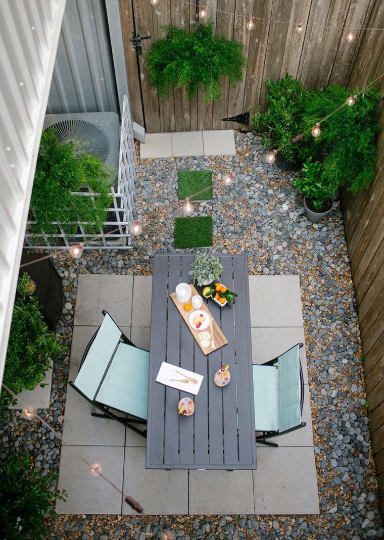 toit terrasse joliment aménagé avec bancs, coussins et plantes
