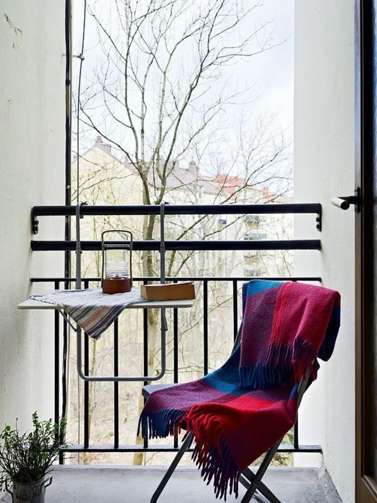 un petit balcon avec table, chaise et déco superbe