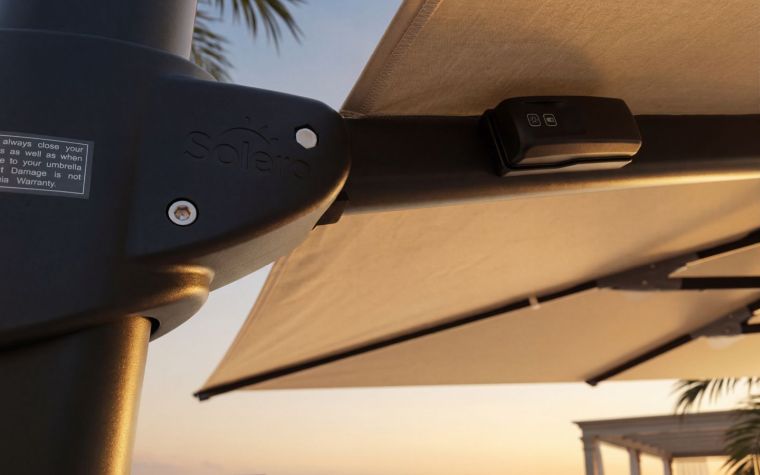 Gros plan sur un parasol déporté moderne avec toile beige et commande intégrée, installé sur une terrasse extérieure