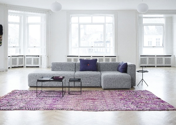 Tapis violet devant un canapé gris