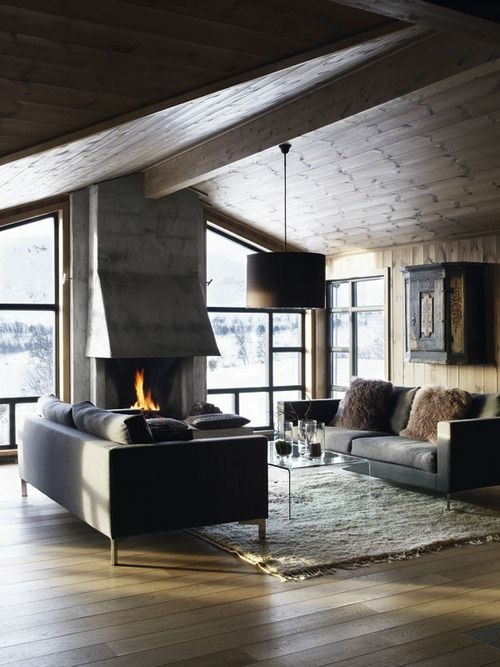 chalet bois beton cheminee feu foyer coussins planche