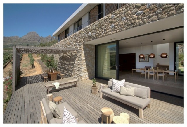 Une des terrasses confortables de la maison falaise  vue montagne vignes bois revêtement sol 