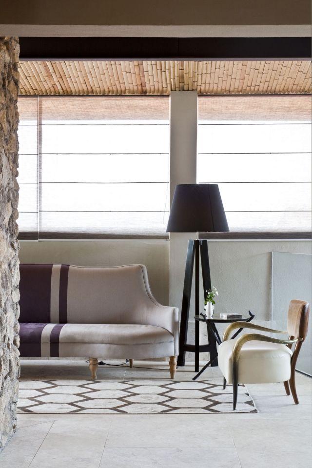 luminaire-salon-lampe-pied-noire-élégante-canapé-chaise-cuir-élégants-tapis-blanc-motifs-marron