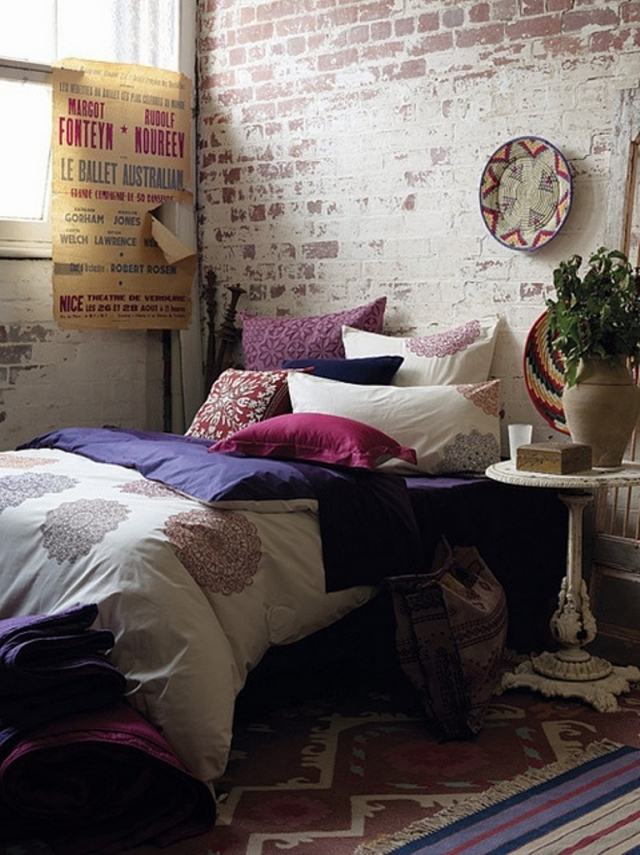 papier-peint-brique-chambre-coucher-style-industriel-coussins-décoratifs-tapis-bariolé